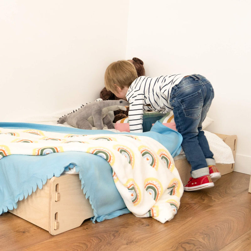 boy getting into eco floor bed with accessories